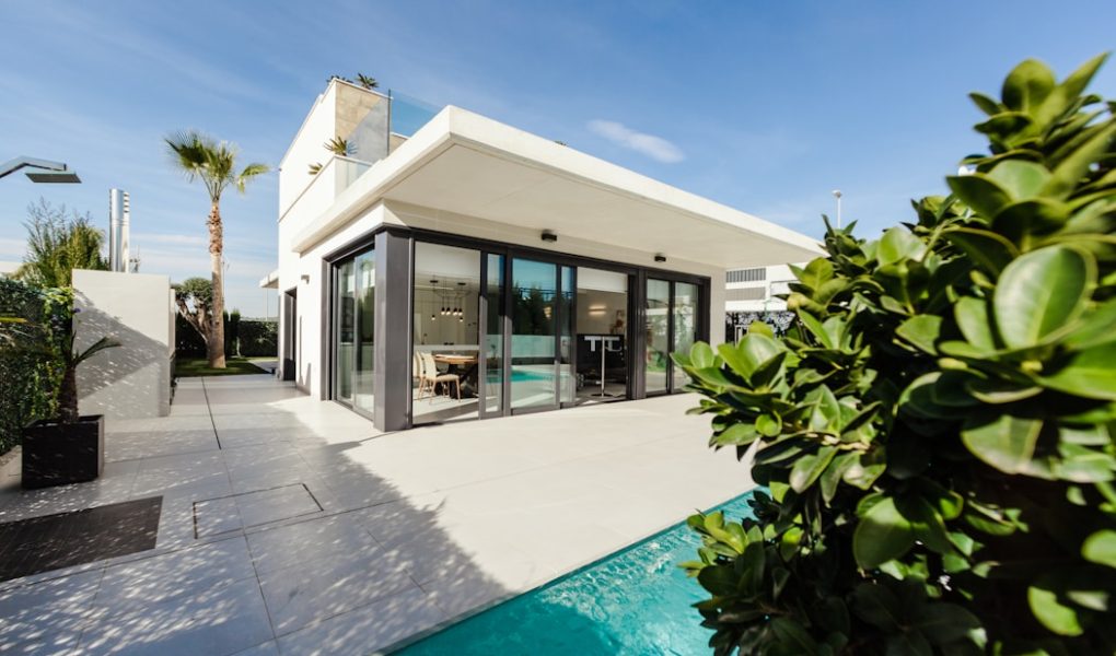 white and grey concrete building near swimming pool under clear sky during daytime