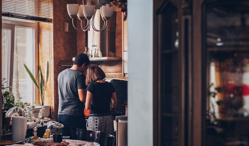 man and woman standing in front of gas range