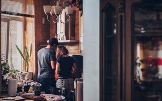 man and woman standing in front of gas range