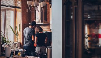 man and woman standing in front of gas range