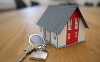 white and red wooden house miniature on brown table