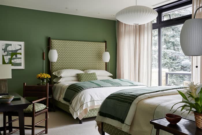 Cottagecore green bedroom with floral bedding, a patchwork quilt, and vintage accents