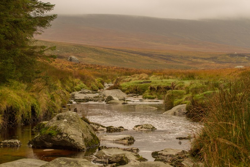 County Wicklow Ireland countryside with a stream, rocks, and rolling hills near Hozier's home