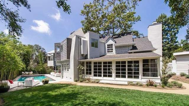 Exterior of Niall Horan's former Hollywood Hills home showing the contemporary white stucco house with swimming pool, manicured lawn, and the Frank Gehry-renovated design