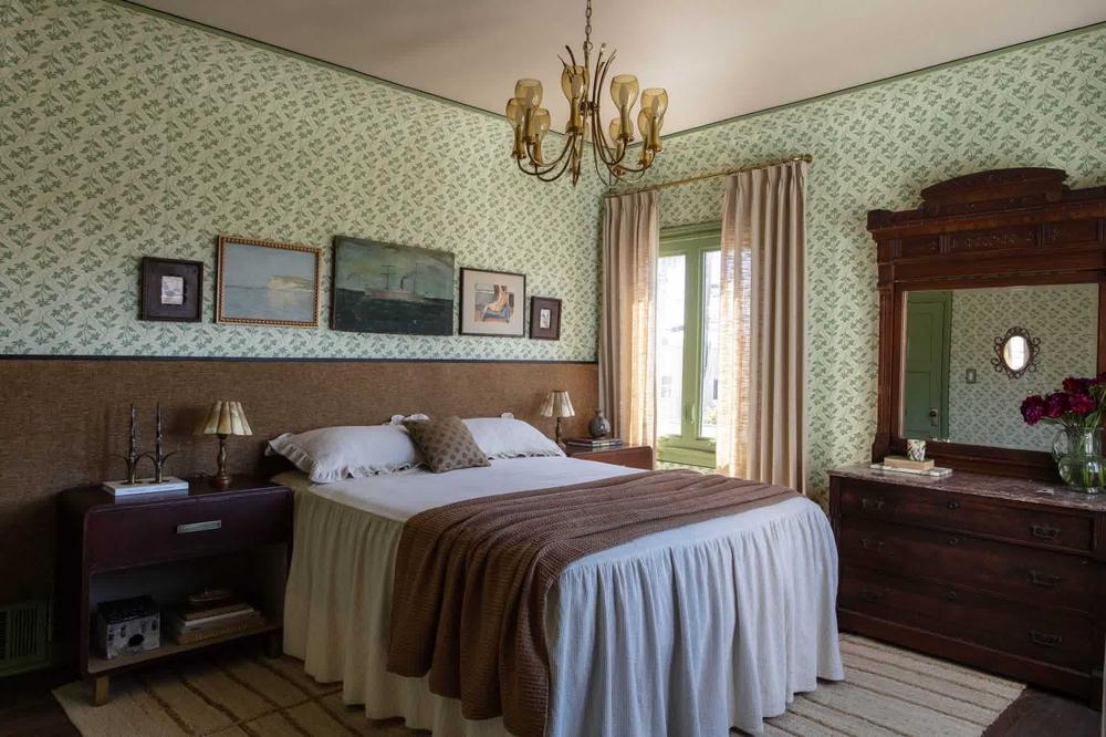 Green and grey bedroom with a charcoal accent wall and soft sage bedding