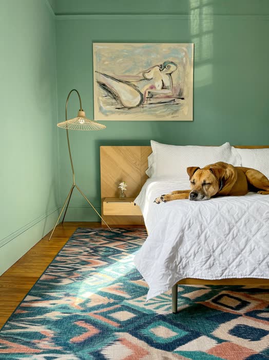 Green and white bedroom with crisp white bedding against sage green walls