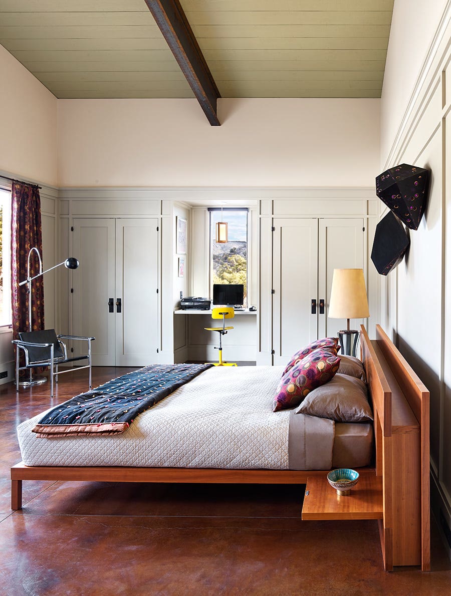 Japandi-style green bedroom with minimal light wood furniture and a low platform bed