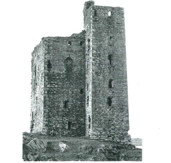 Kilcoe Castle before restoration, showing ruined stone walls, roofless towers, and overgrown vegetation in its dilapidated state