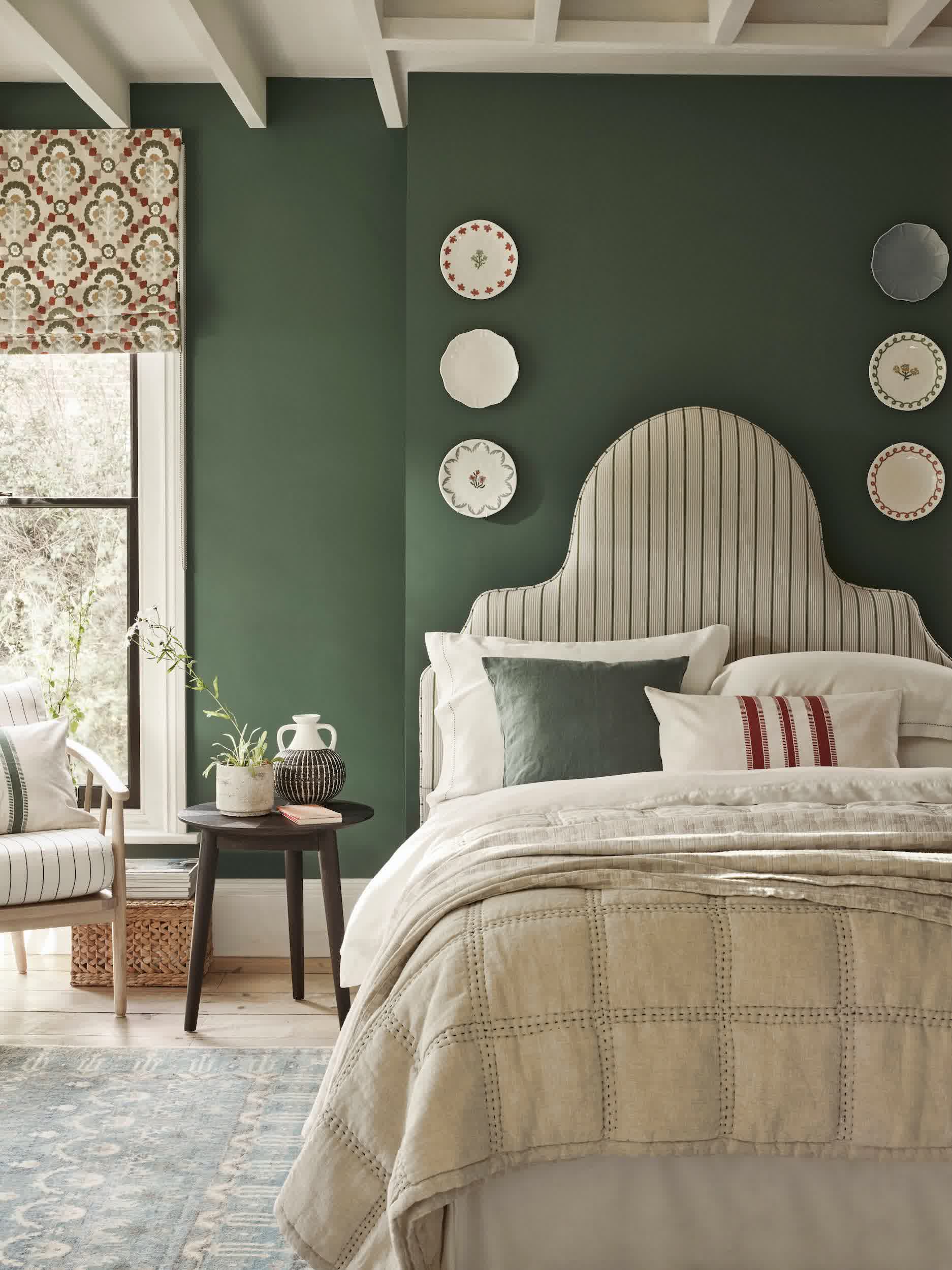 Light green wall paneling below white upper walls in a bedroom with dark wood furniture
