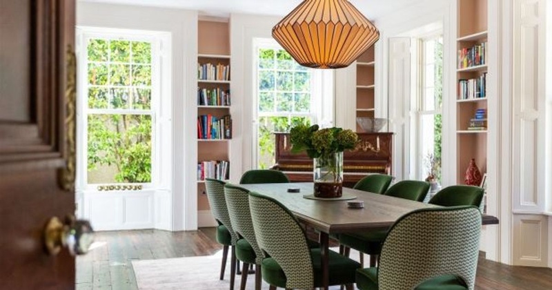 Saoirse Ronan dining room with wooden table built-in bookcases and stone fireplace at Pine Lodge