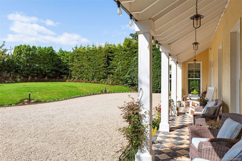 Saoirse Ronan outdoor covered veranda with checkerboard tiling overlooking lawn at Pine Lodge
