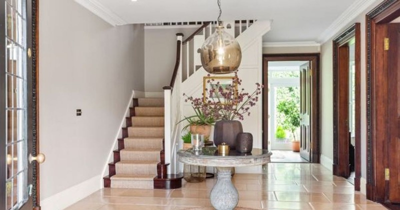 Saoirse Ronan Pine Lodge entrance hall with carved wood staircase and cream stone floors