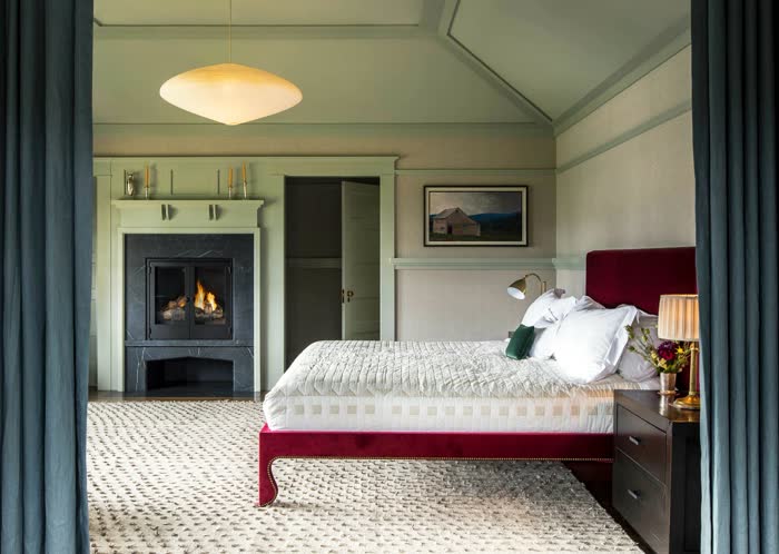Scandinavian green bedroom with white oak furniture, a knit throw, and pale sage walls