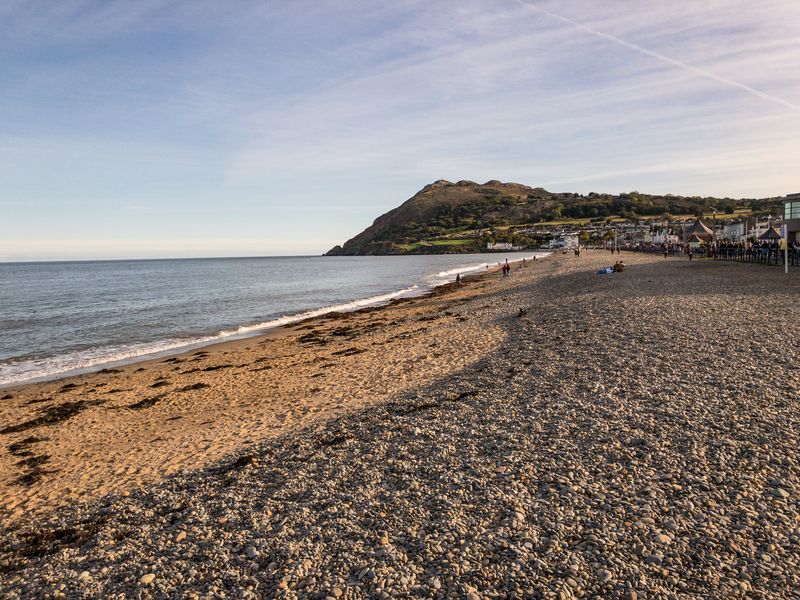 Seaside Bray, County Wicklow, Ireland, Hozier's hometown, features a pebbly beach, calm waters, and a coastal hill