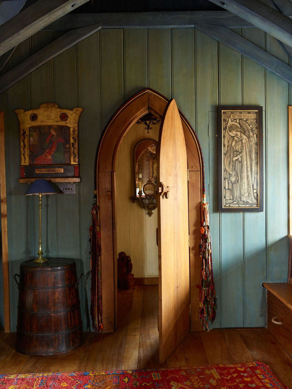 The Solar, Kilcoe Castle’s main living area, featuring an arched doorway, teal paneled walls, tapestries, and warm historic atmosphere