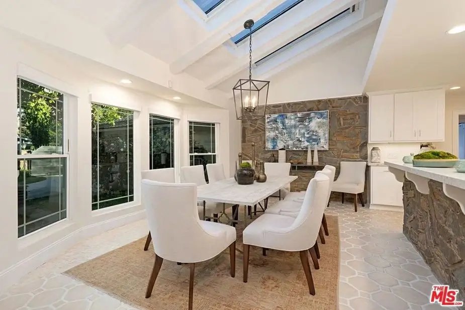 Tom Segura’s Austin lakefront mansion dining room with skylights, marble table, and stone details.